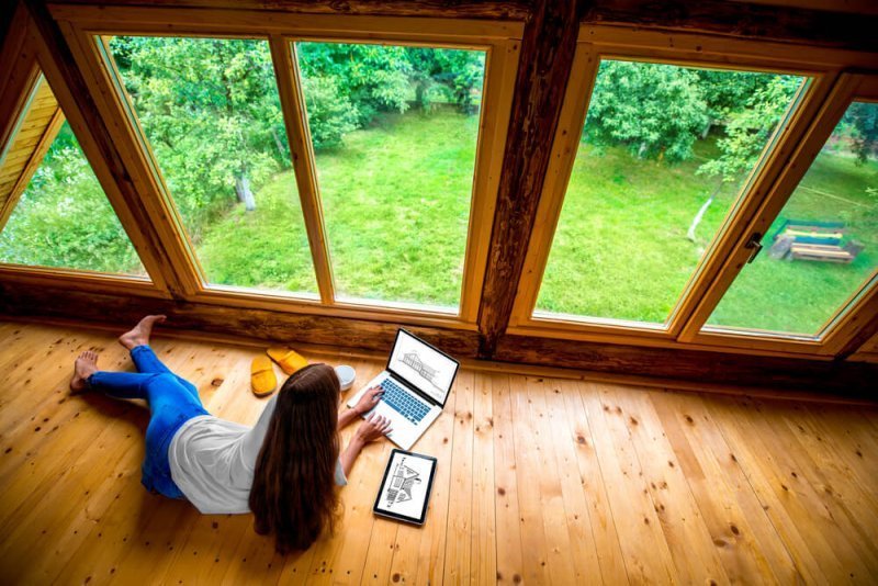 žena ležící na podlaze a pracující na svém notebooku